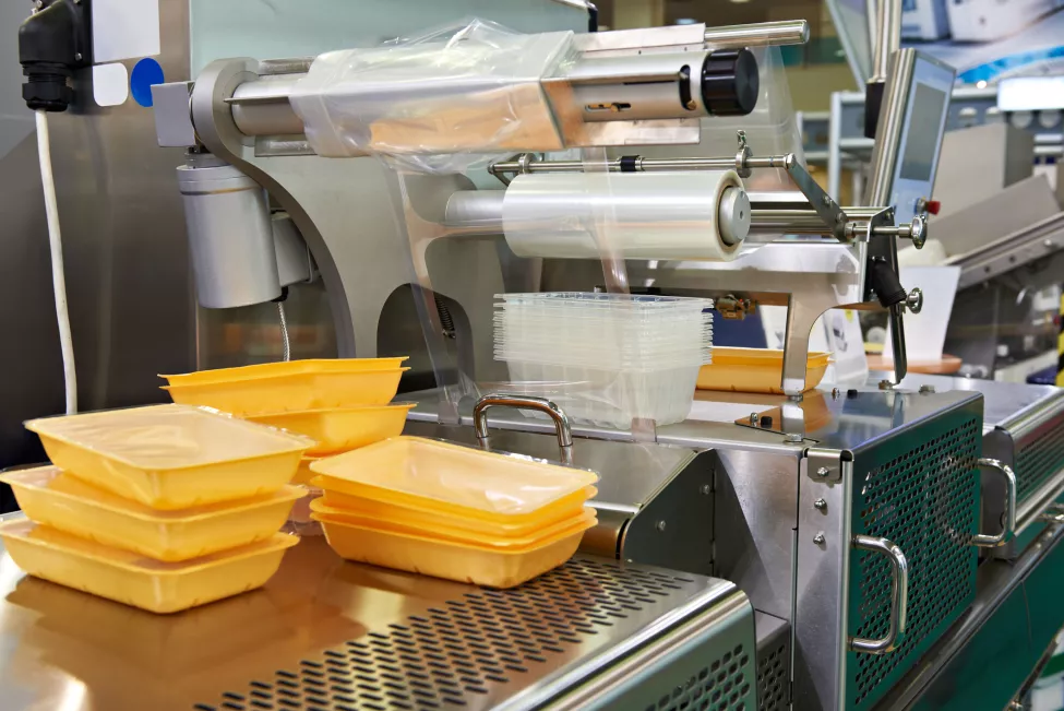 Food packaging trays on sealing equipment